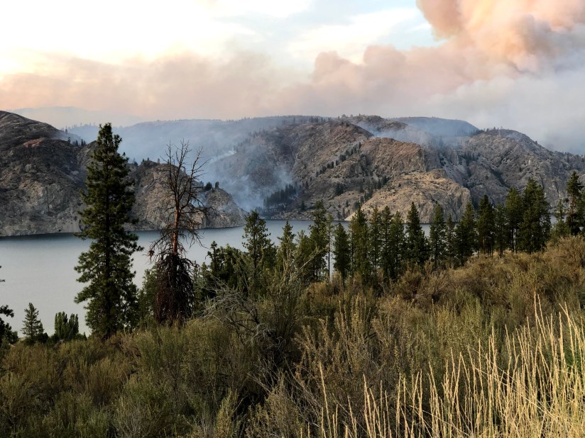 2019 wildfire along Lake Roosevelt -- smoke in sky and down the hills to the lake